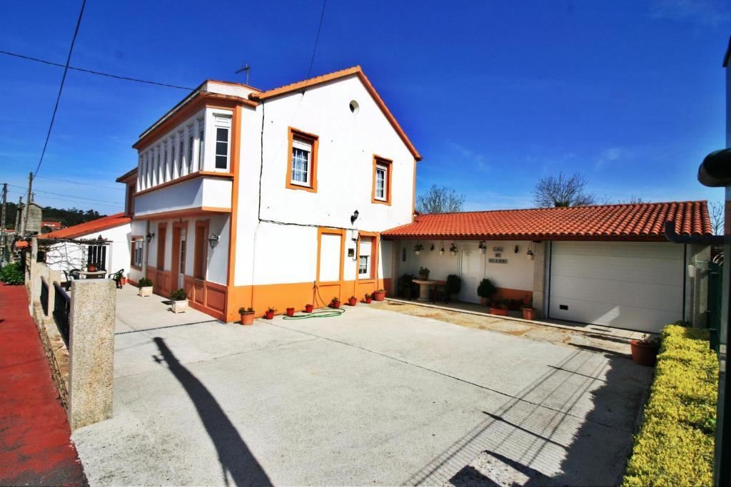 une maison blanche avec un toit rouge dans l'établissement Casa do Relojero, à Zas