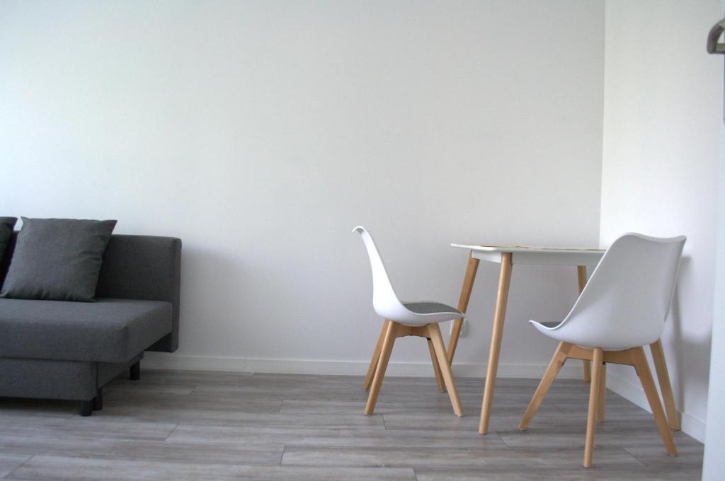 een woonkamer met een tafel en 2 stoelen bij Apartment Mostek 5 minutes walk from the Old Town in Gdańsk