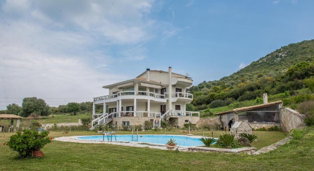a large house with a pool in front of it at Villa Virginia in Vonitsa