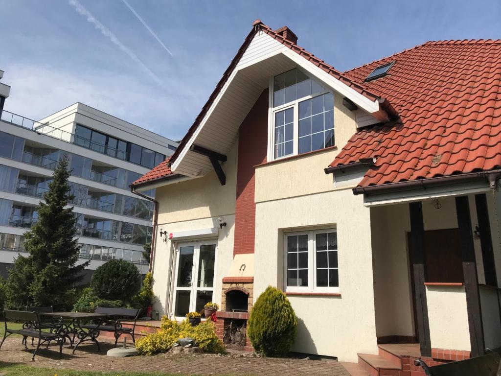 una casa con tetto rosso e un edificio di Dom Przy Plaży a Mielno
