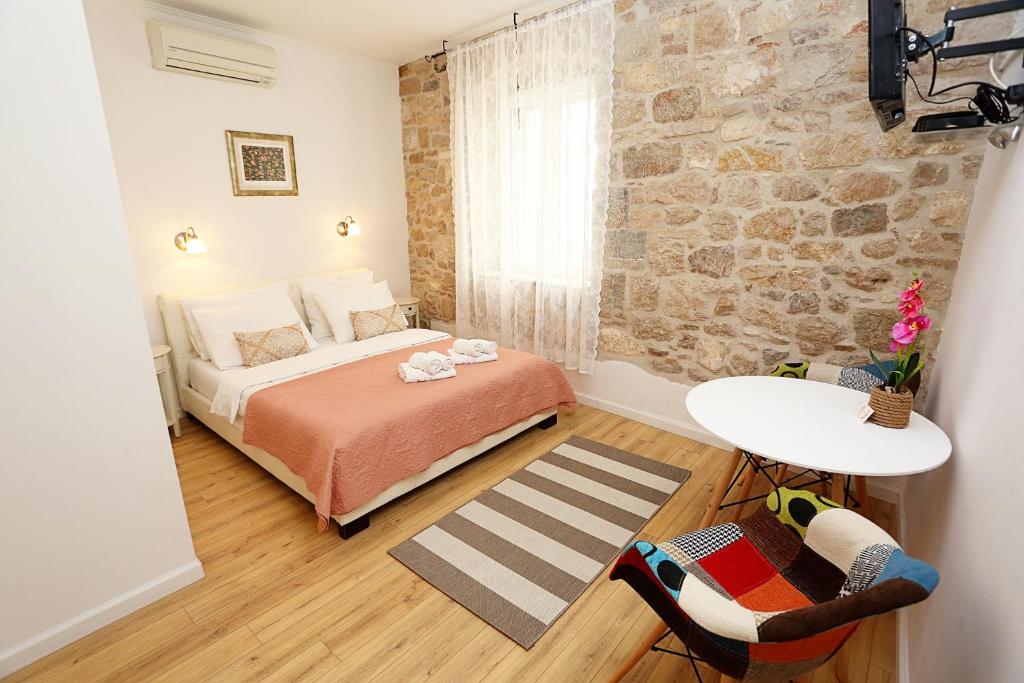 sypialnia z łóżkiem i kamienną ścianą w obiekcie Split Old Town Suites w Splicie