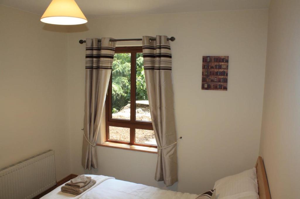 a bedroom with a bed and a window at Butterfly cabin in Limerick