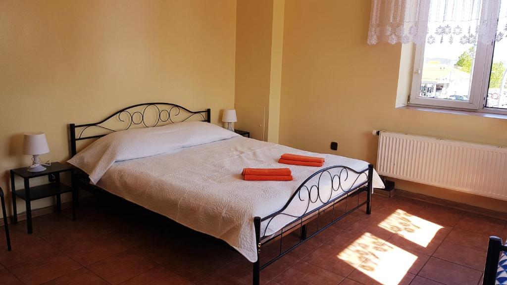 a bedroom with a bed with two orange towels on it at Pokoje Gościnne Relaks in Gdynia