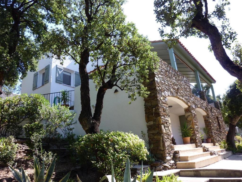 una casa con un árbol delante de ella en Les mimosas en Collioure