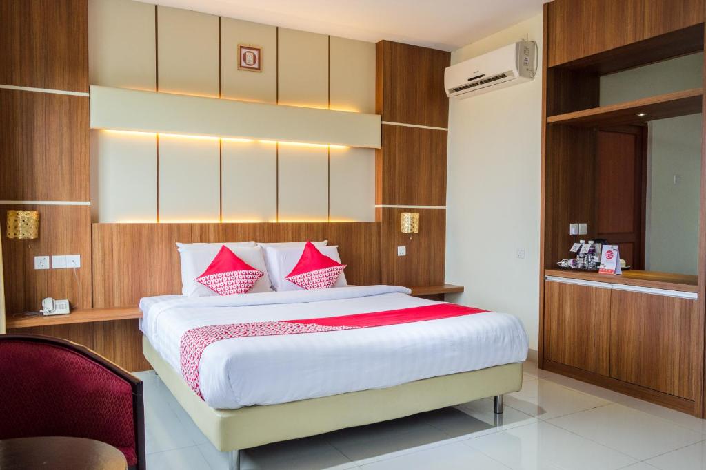 a bedroom with a large bed with red pillows at Aviari Hotel in Sekupang