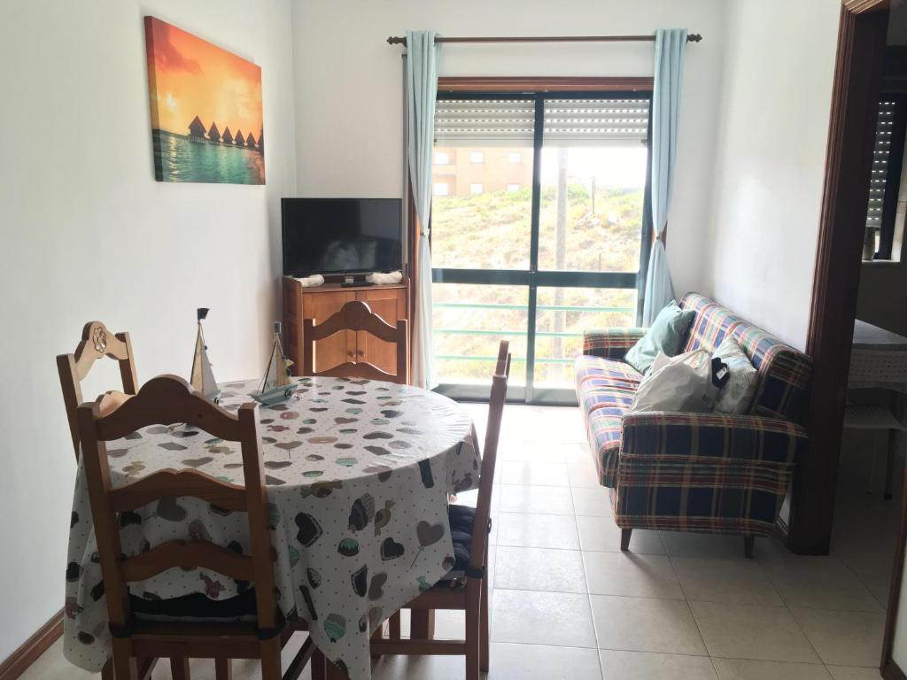 een eetkamer met een tafel en stoelen en een raam bij Mira House in Praia de Mira