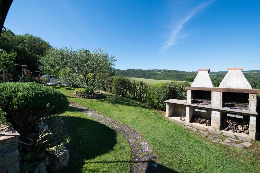un jardin avec un bâtiment en herbe dans l'établissement Villa La Francigena, à San Gimignano