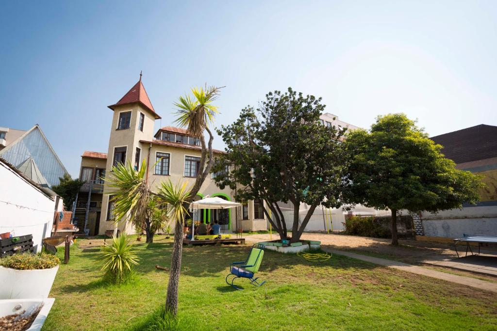 una casa con una palmera y un banco en un patio en Viña City Hostel II, en Viña del Mar