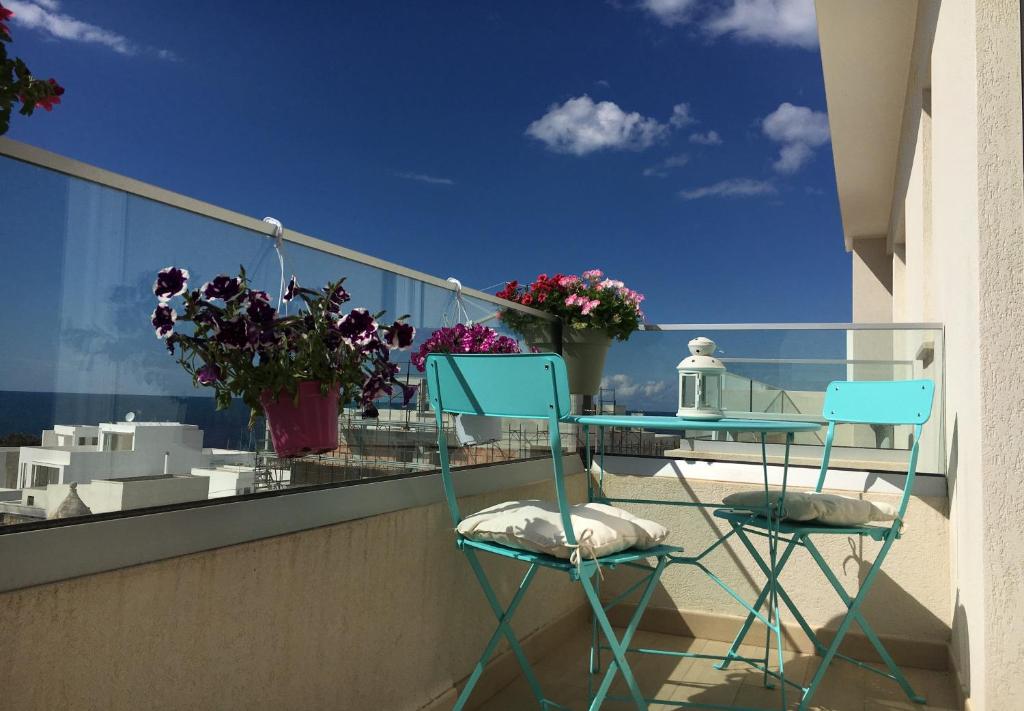 einen Balkon mit 2 Stühlen, einem Tisch und Blumen in der Unterkunft Teti Holiday Home in Polignano a Mare