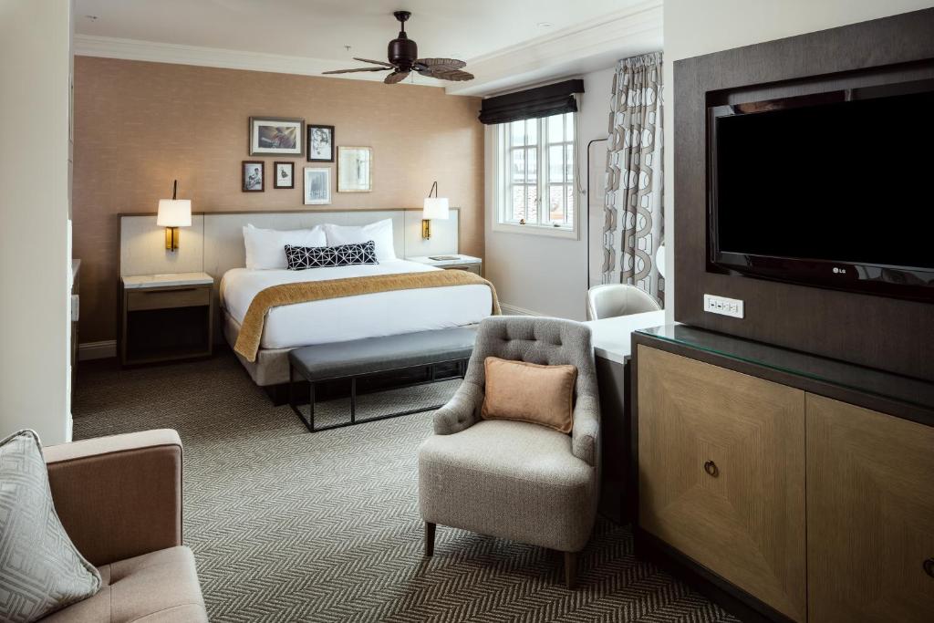 a hotel room with a bed and a flat screen tv at La Valencia Hotel in San Diego