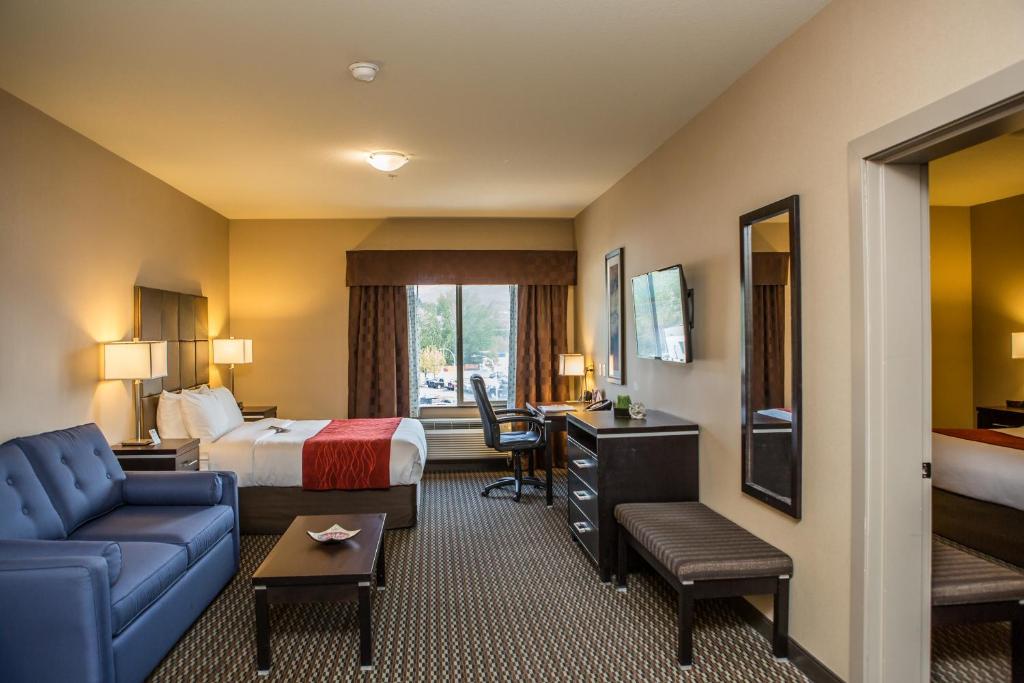 Comfort Suites في كيلونا: غرفة في الفندق مع سرير وأريكة ومكتب