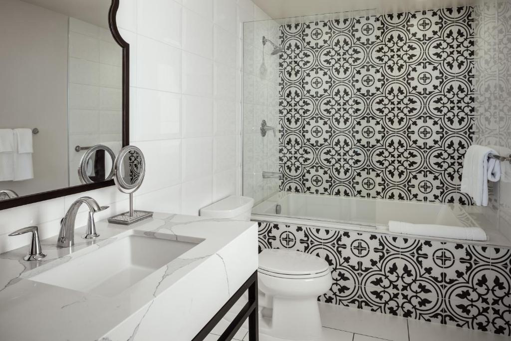 a white bathroom with a toilet and a shower at La Valencia Hotel in San Diego