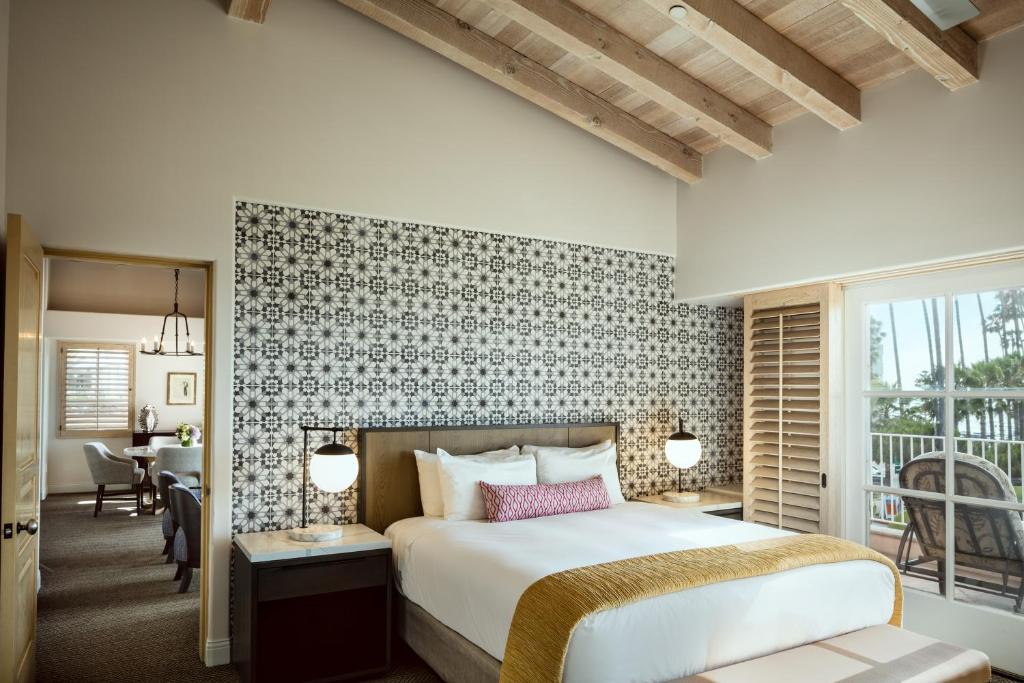 a bedroom with a bed and a dining room at La Valencia Hotel in San Diego