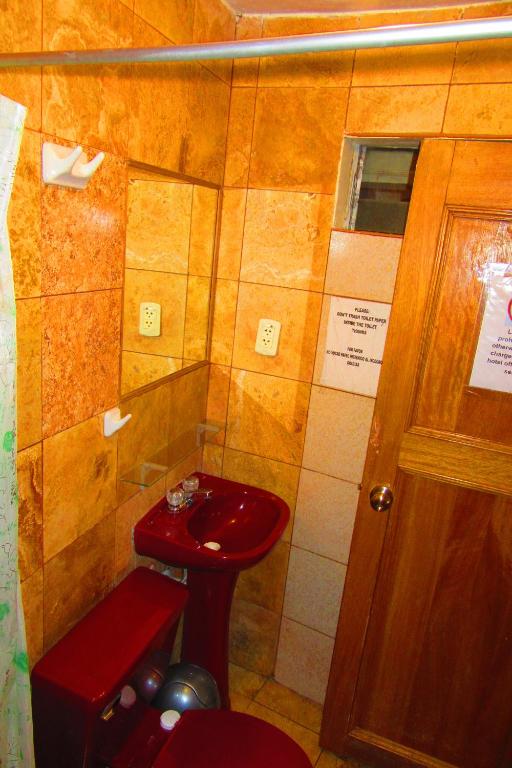 a bathroom with a red sink and a door at Hospedaje Kamila in Cusco