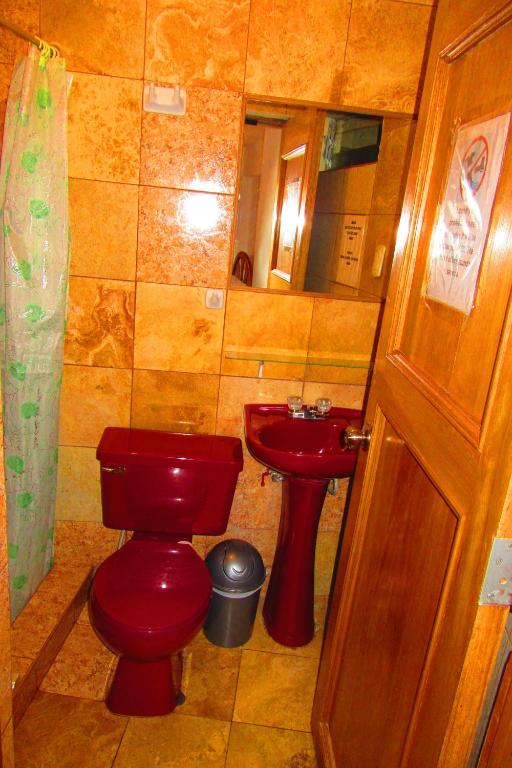 a bathroom with a red toilet and a sink at Hospedaje Kamila in Cusco