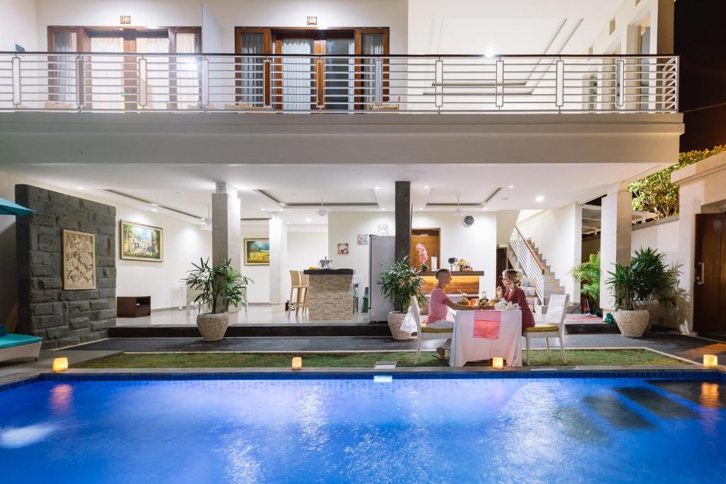 een villa met een zwembad en een woonkamer bij Kubu Benoa Guest House in Nusa Dua