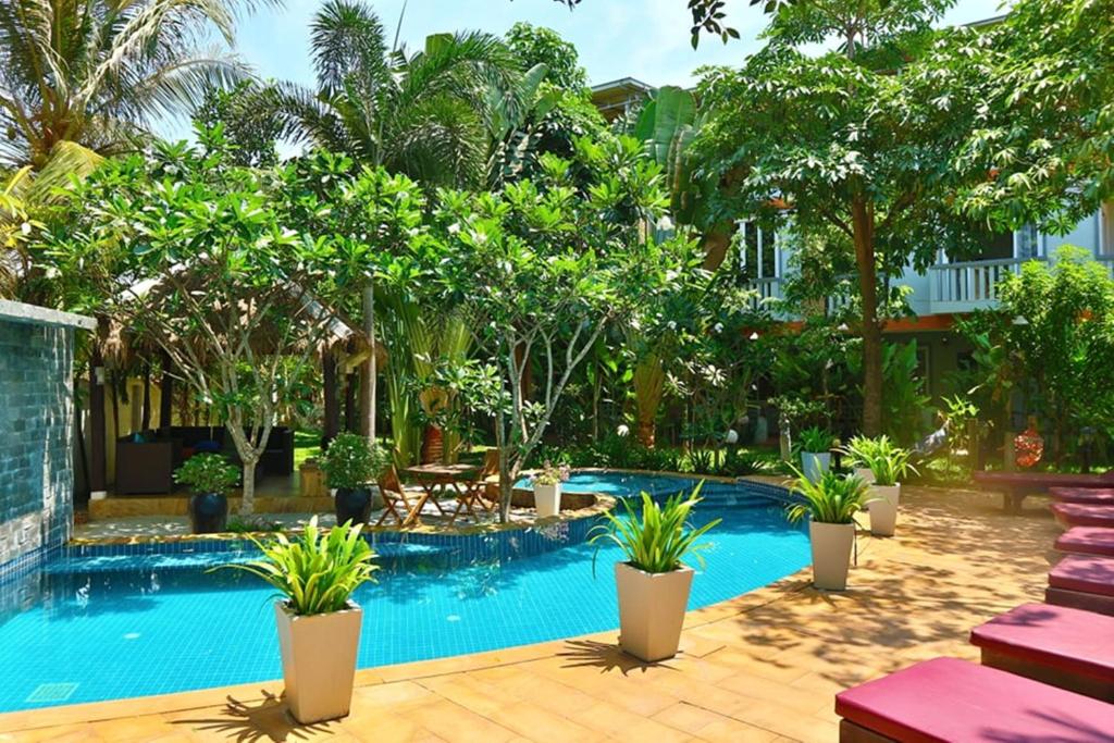 een zwembad met planten in een resort bij Hak Boutique Residence in Siem Reap
