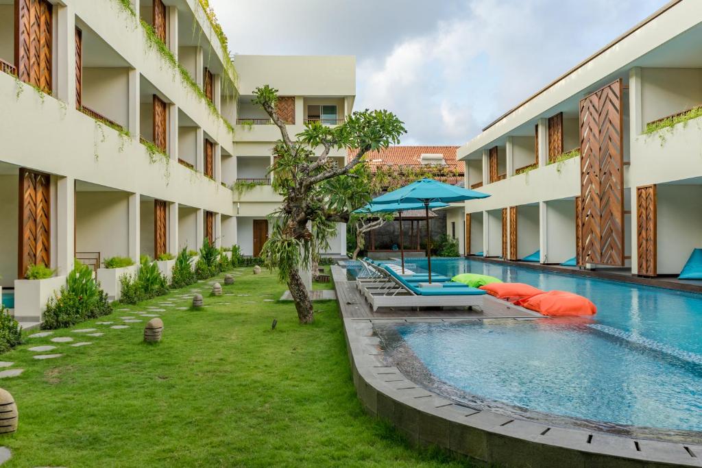 an outdoor swimming pool next to a building at Anja Jimbaran in Jimbaran