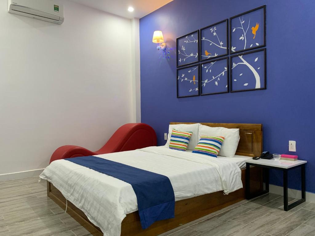 - une chambre avec un lit et un mur bleu dans l'établissement Khách sạn Đăng Khoa, à Cao Lãnh