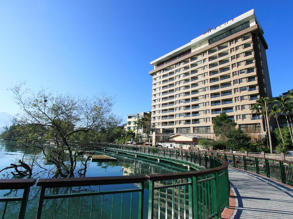 a large building next to a body of water at Sun Moon Lake Hotel in Yuchi