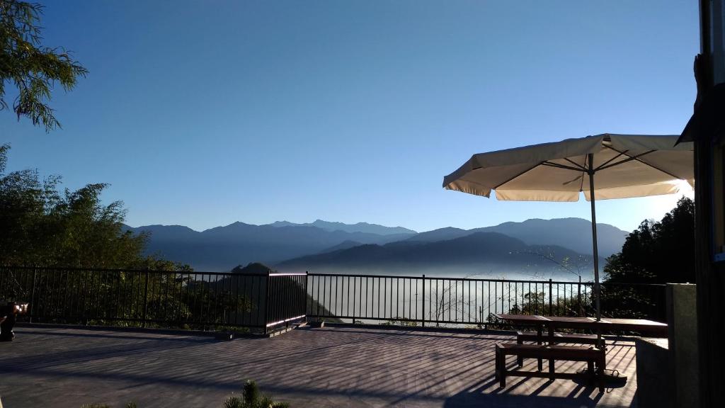 une terrasse avec une table et un parasol dans l'établissement Miao Home, à Fanlu