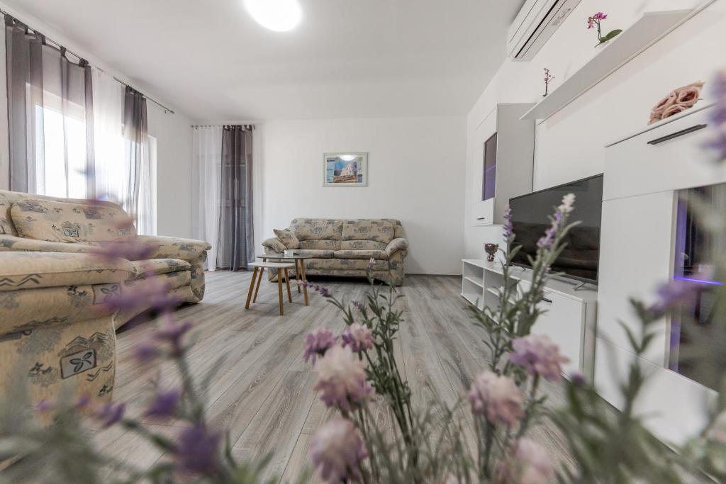 uma sala de estar com um sofá e uma mesa em Apartment Tragurion em Trogir