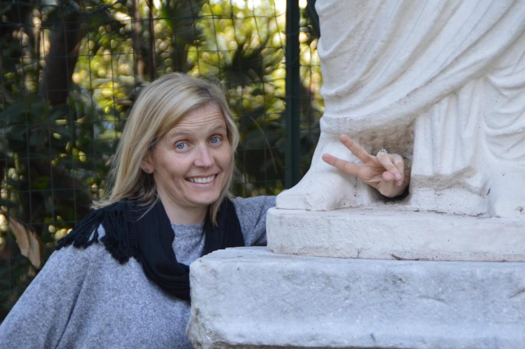 Uma mulher está ao lado de uma estátua. em Casa Vacanze Zio Gionni em Roma