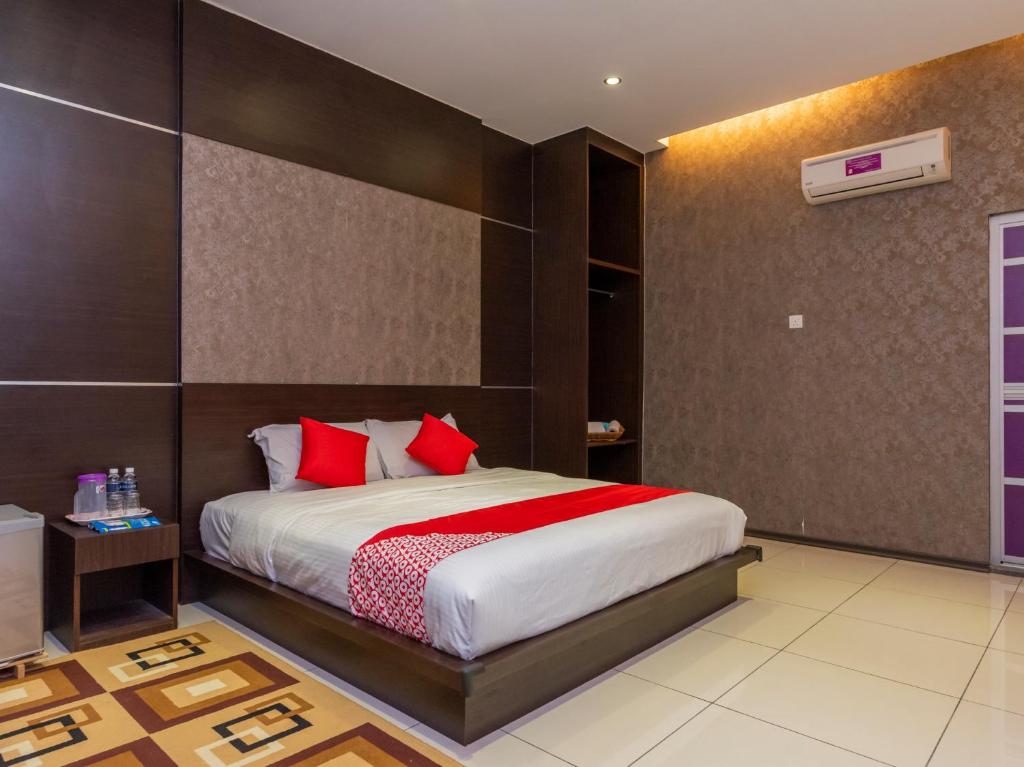 um quarto com uma cama grande e almofadas vermelhas em REMEMBER HOTEL BUKIT GAMBIR em Pagoh