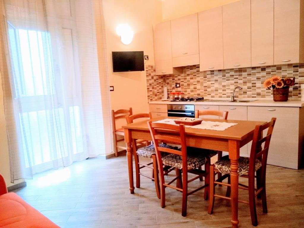 a kitchen with a wooden table and chairs in a room at Casa dei Girasoli in Taormina