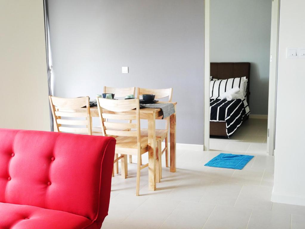 una sala da pranzo con tavolo e sedia rossa di Tamarind Suites by Elite Stay a Cyberjaya