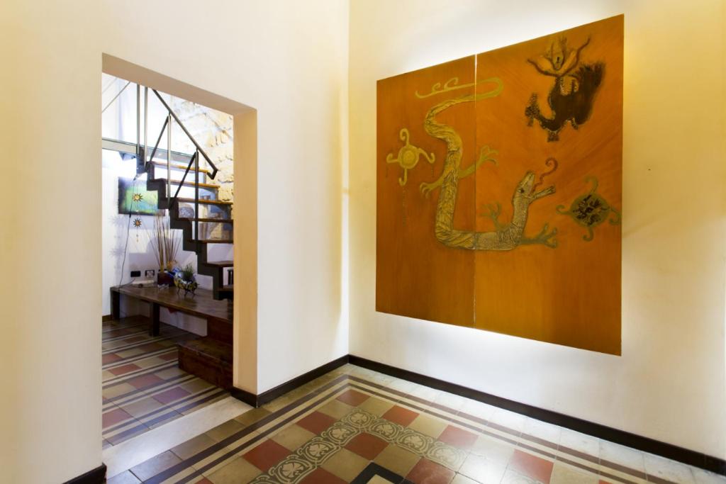 un couloir avec un grand tableau sur le mur dans l'établissement Il Drago e la Fenice, à Palerme