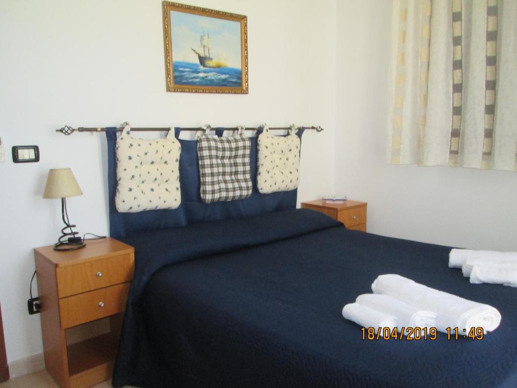 a bedroom with a large bed with blue sheets and pillows at Casa Nik in San Vito lo Capo