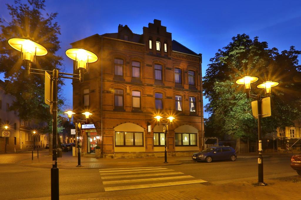 un bâtiment avec des lumières de rue devant un bâtiment dans l'établissement 1891 Hildesheim Boutique Hotel, à Hildesheim