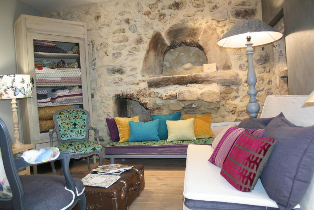 a living room with a couch and a stone wall at Le domaine des rouges queues in Châteaudouble