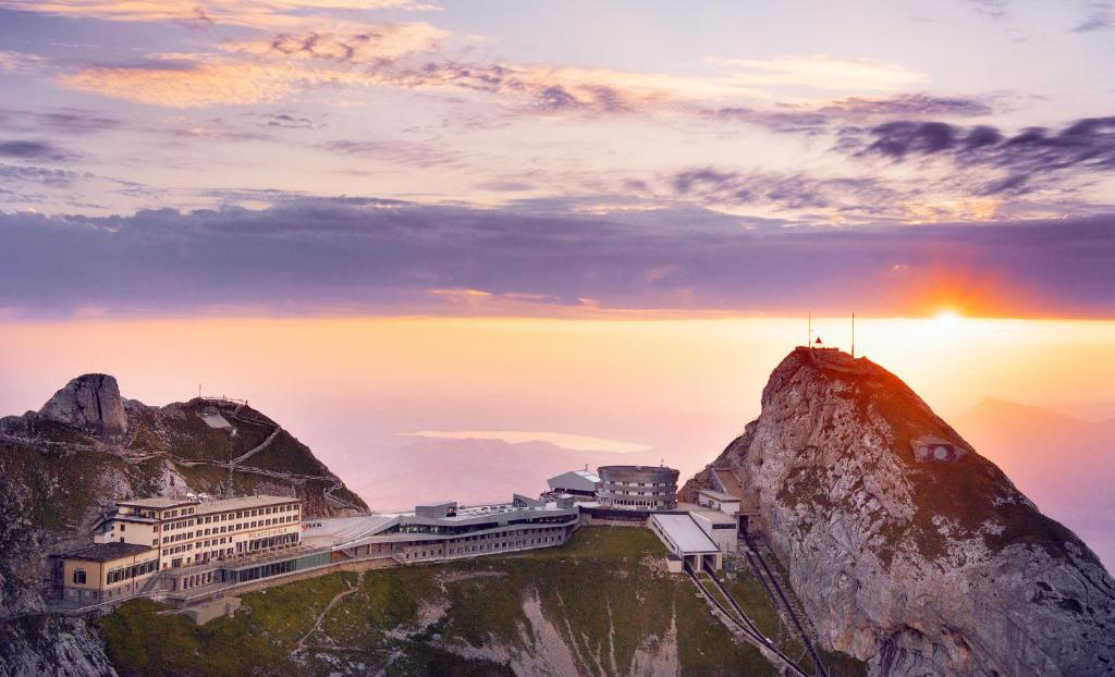 ein Gebäude auf einem Berg bei Sonnenuntergang in der Unterkunft Hotel Pilatus-Kulm in Luzern