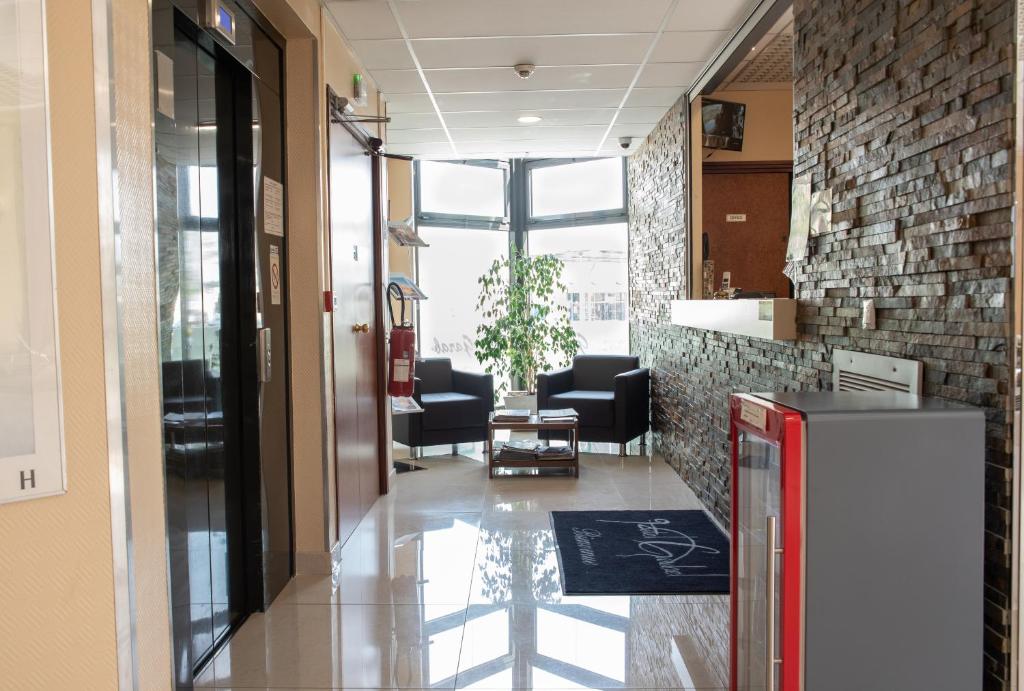 a hallway of a office with chairs and a refrigerator at Hôtel Garabel in Plaisir