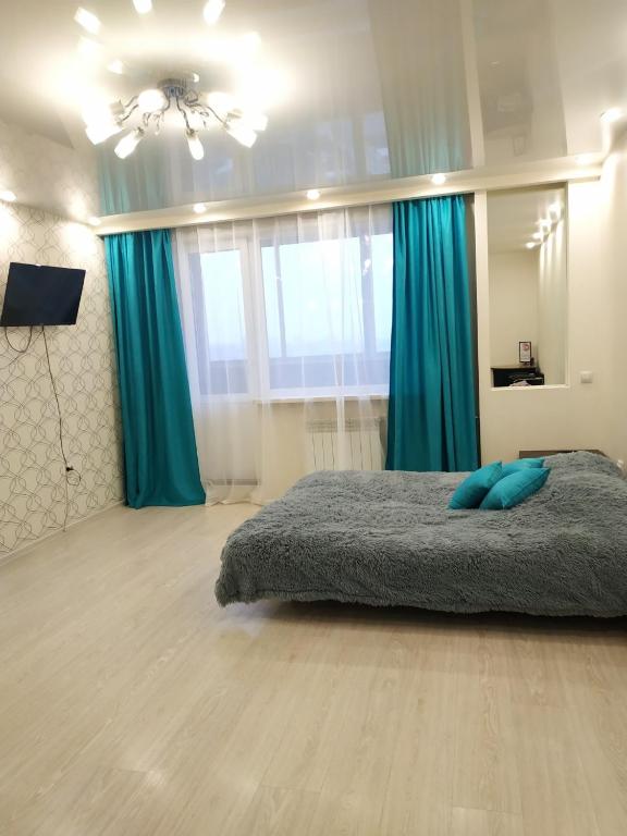 イルクーツクにあるАпартаменты на Космическомのベッドルーム1室(青い枕のベッド1台付)