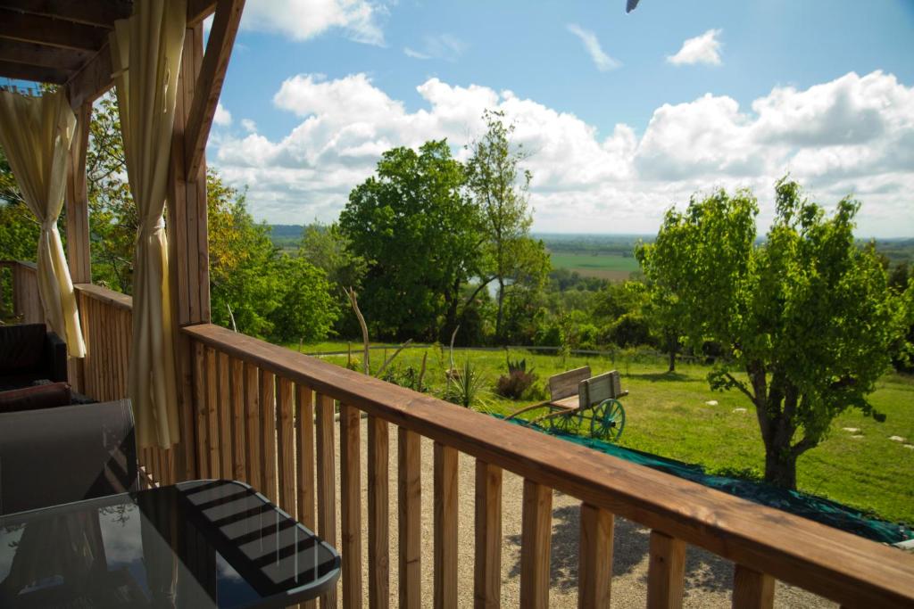 a balcony with a view of a park with a bench at Gîte Les Bourdettes in Auvillar