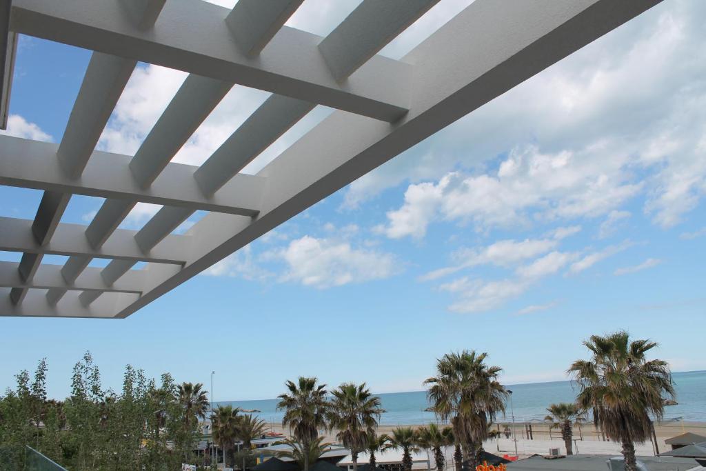 a view of the beach from the balcony of a resort at Soffio del mare in Lido di Fermo