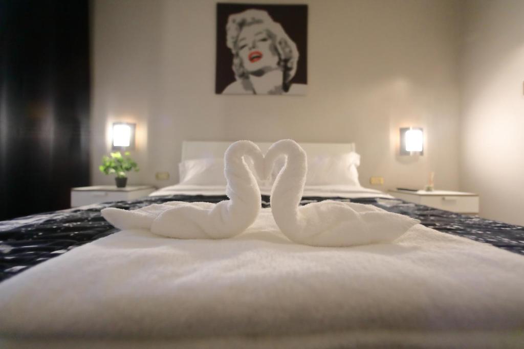 two white swans sitting on top of a bed at SK Home in Peschiera del Garda