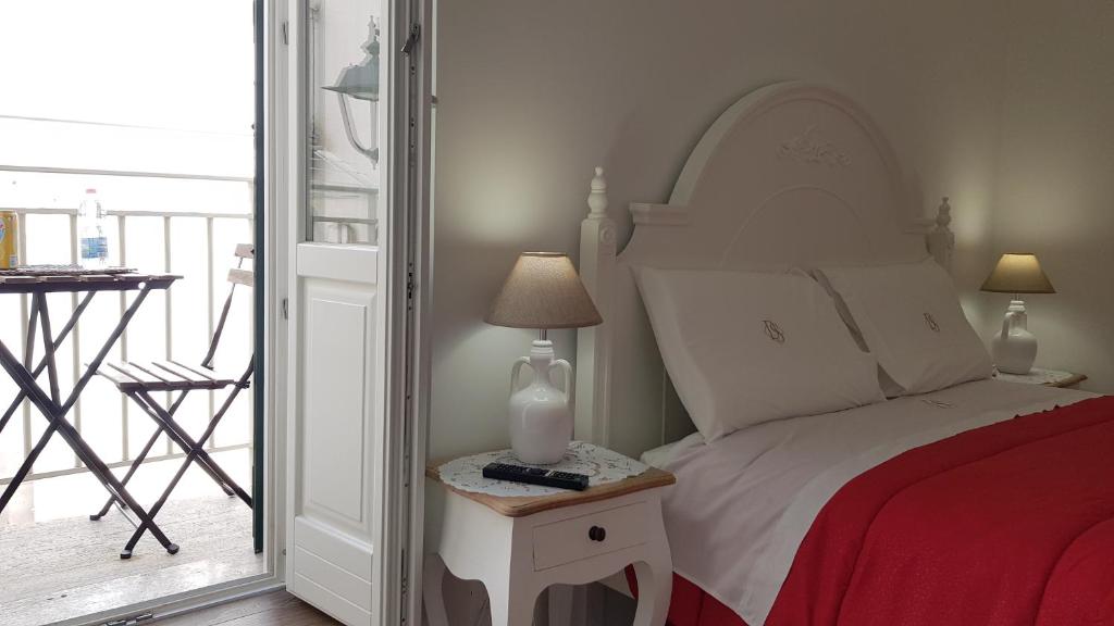 1 dormitorio con 1 cama y 1 mesa con lámpara en La Dimora dei Sorrisi, en Monopoli