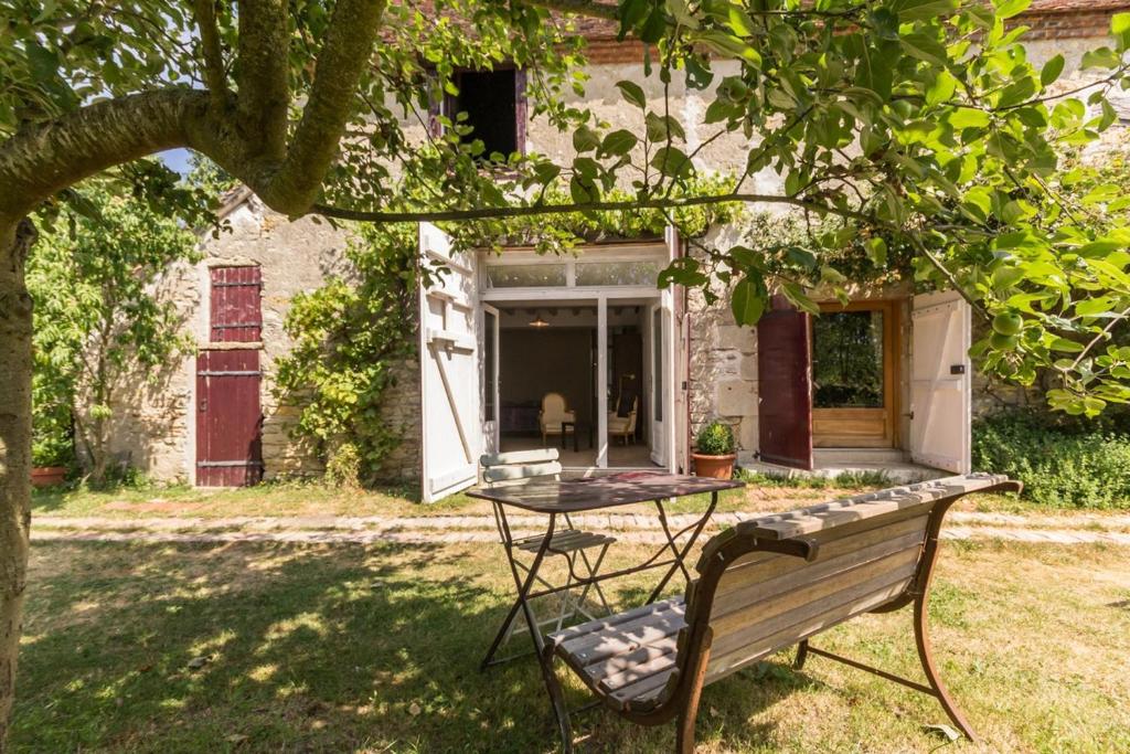 a table and a bench in front of a house at La Thibaude - Livry in Livry