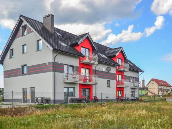 une grande maison blanche et rouge avec un toit noir dans l'établissement Willa Natenczas, à Jarosławiec