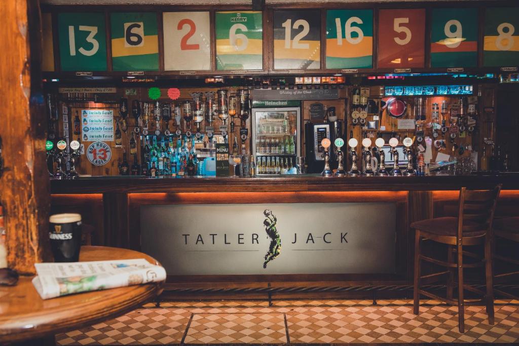 una barra con una mensola di bottiglie di alcol di Tatler Jack a Killarney