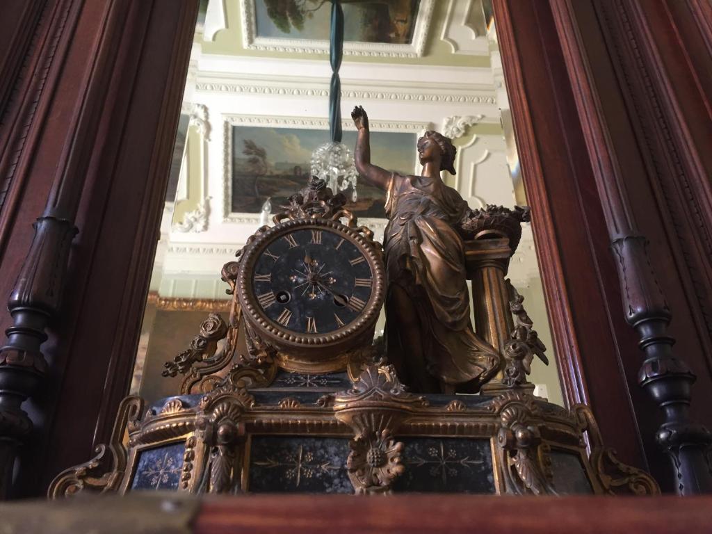 a statue of a woman sitting on top of a clock at Palazzo Laguardia in Fasano