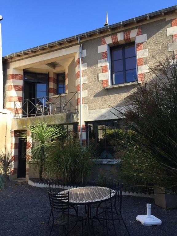 uma mesa e cadeiras em frente a um edifício em Villa Mirabeau em Amboise