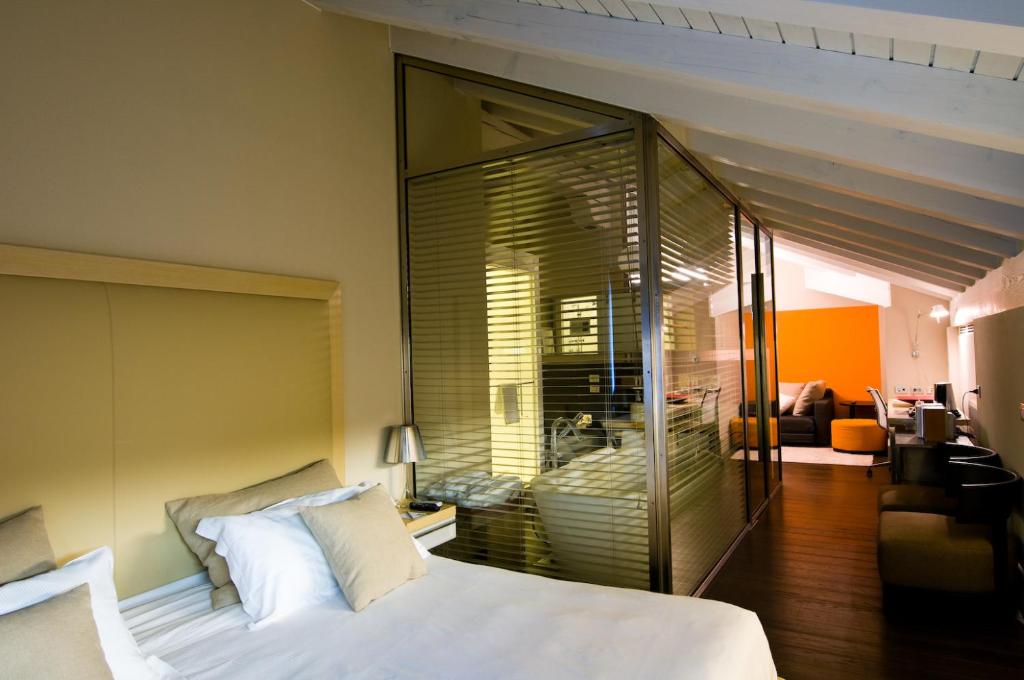 a bedroom with a large white bed and a living room at Active Hotel in Castione della Presolana