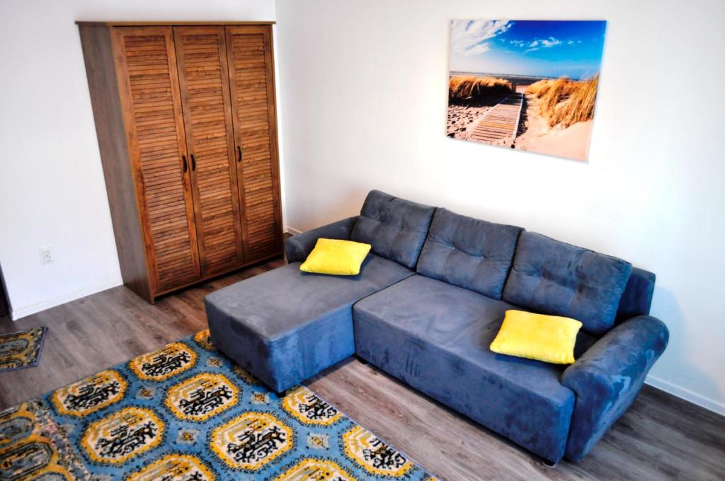 a blue couch in a living room with yellow pillows at Mariuca Apartament in Mangalia