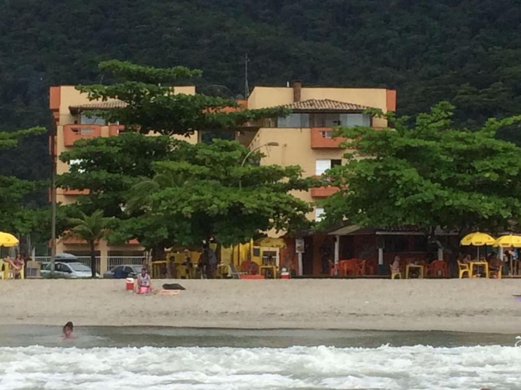 un edificio su una spiaggia con alberi in acqua di Edifício San Rafael a Ubatuba