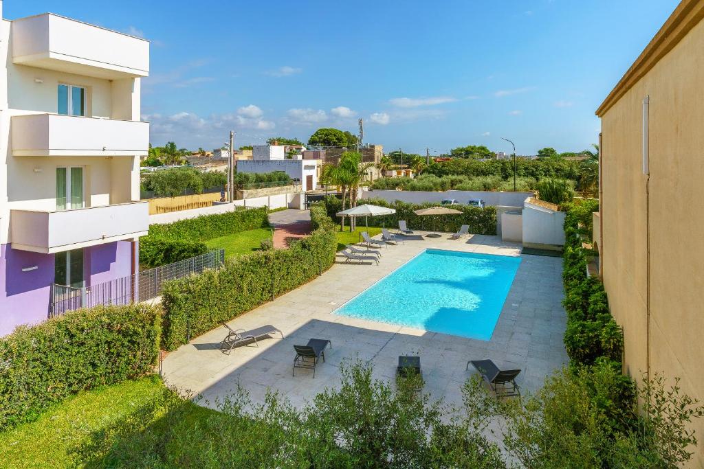 eine Aussicht auf den Pool eines Gebäudes in der Unterkunft Travini Hotel Residence in Marsala